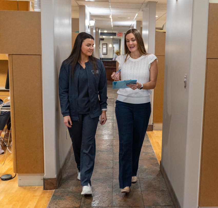 Two female dental staff members walking in the hallway of Pierce & Knight Family Dentistry